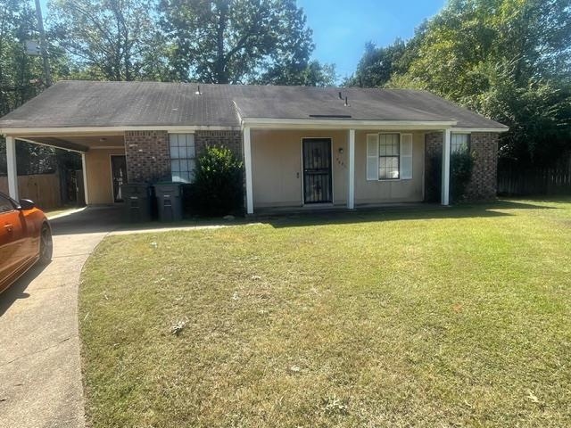 Ranch-style house featuring a front lawn and a carport