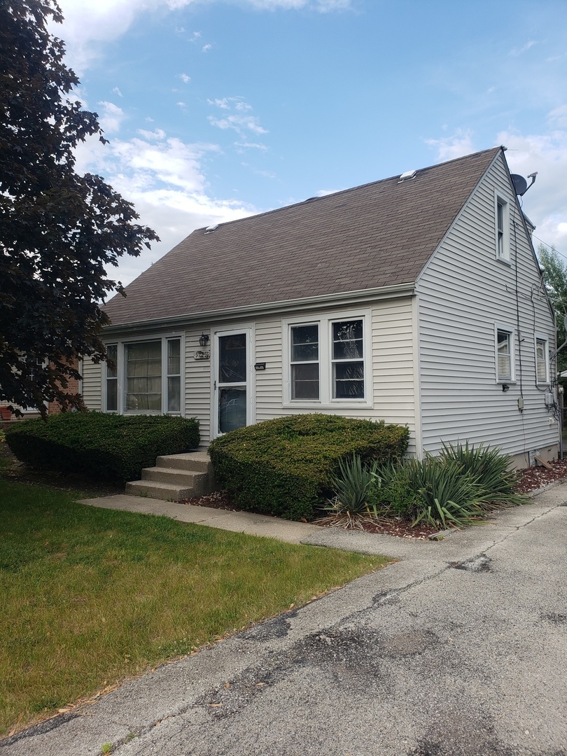 a front view of a house with garden and patio