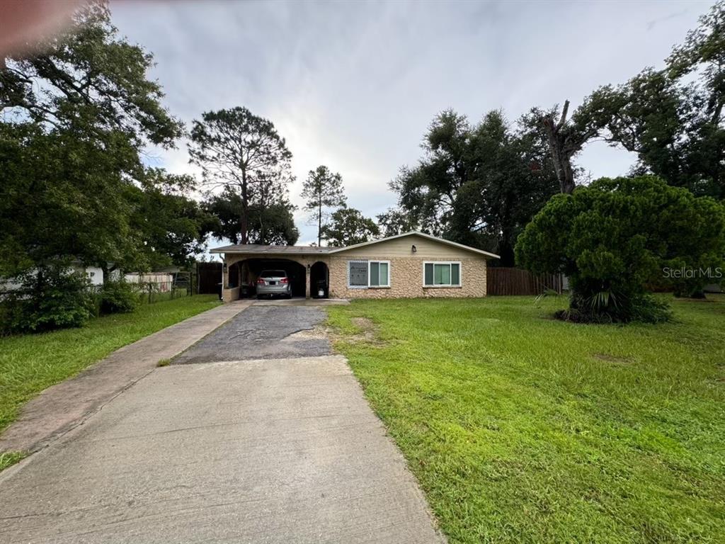 a front view of a house with a yard and trees