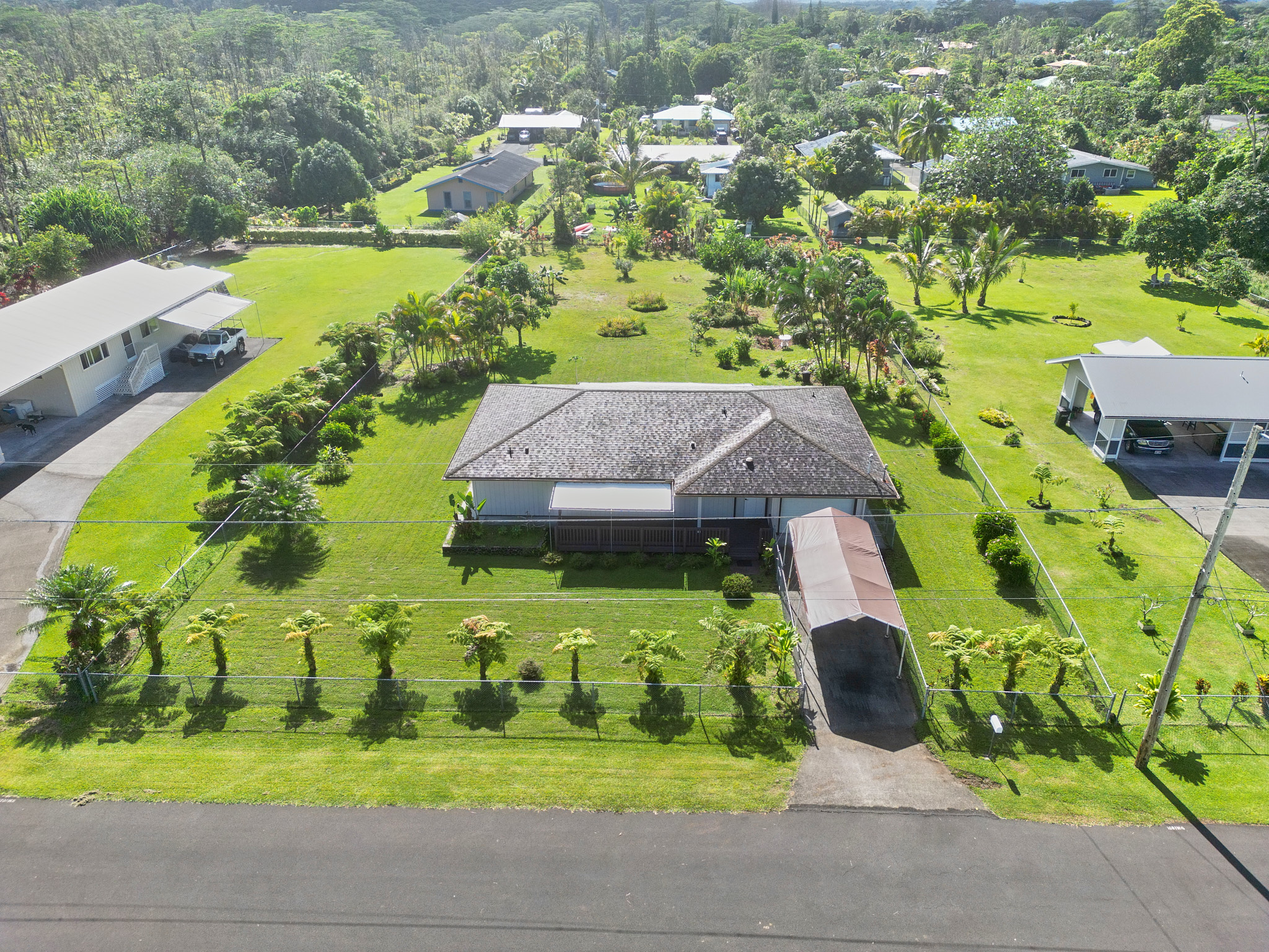 an aerial view of a house with swimming pool and green space