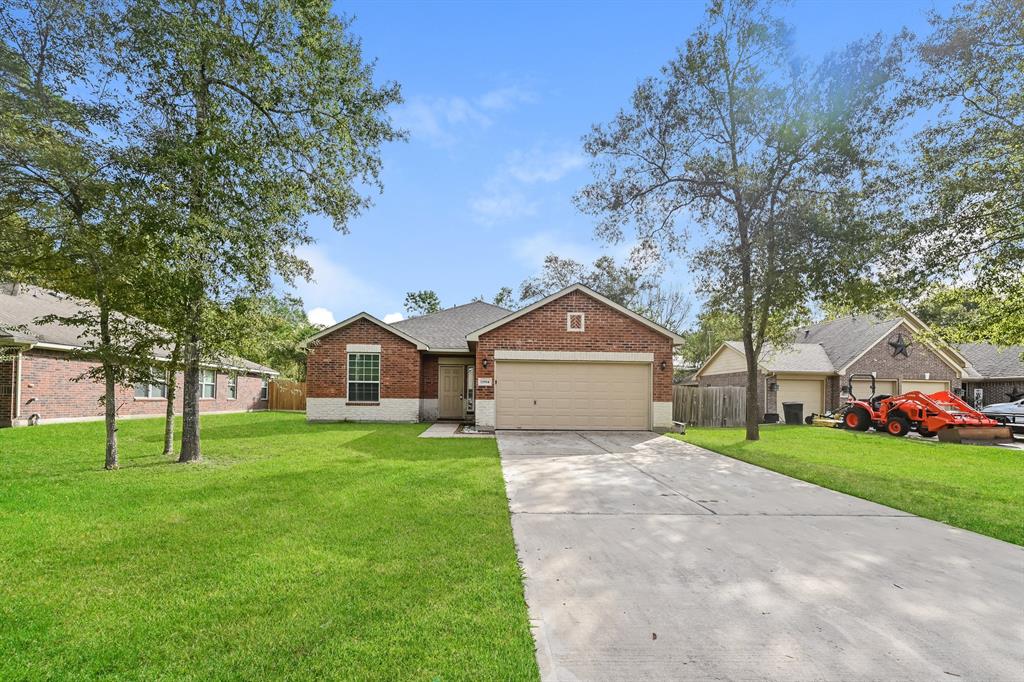 a front view of a house with a yard and trees