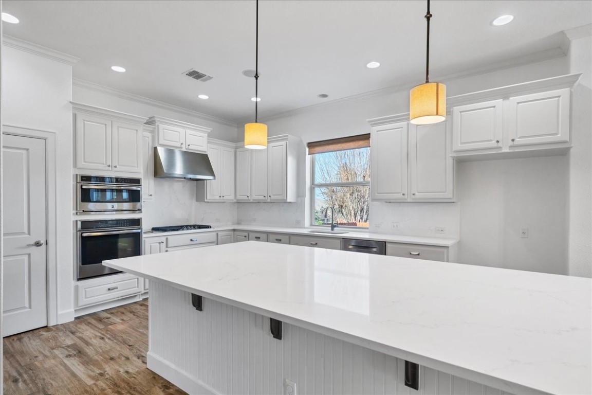 The kitchen has been beautifully updated with stunning quartz counters and slab quartz backsplash, along with fresh paint.