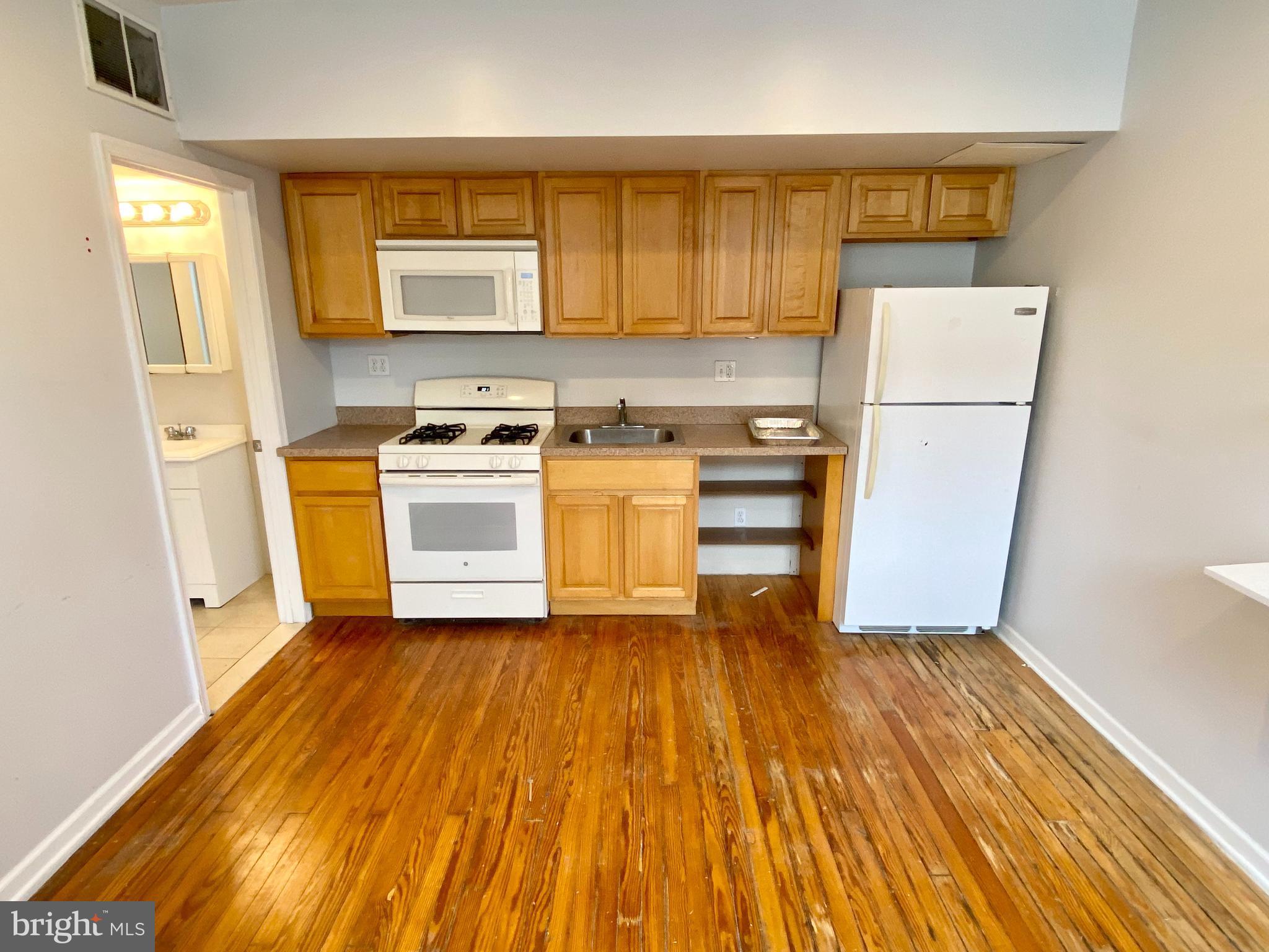 a kitchen with a sink wooden floor and stainless steel appliances