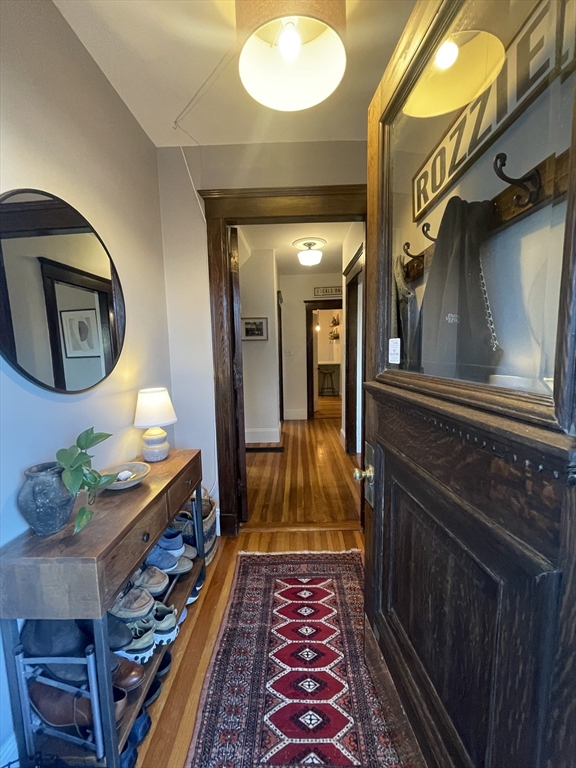 a hallway with painting on the wall and a mirror