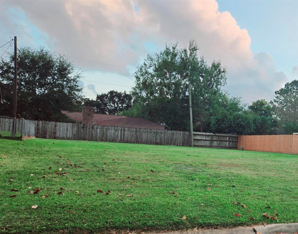 a view of a yard with a fence and trees