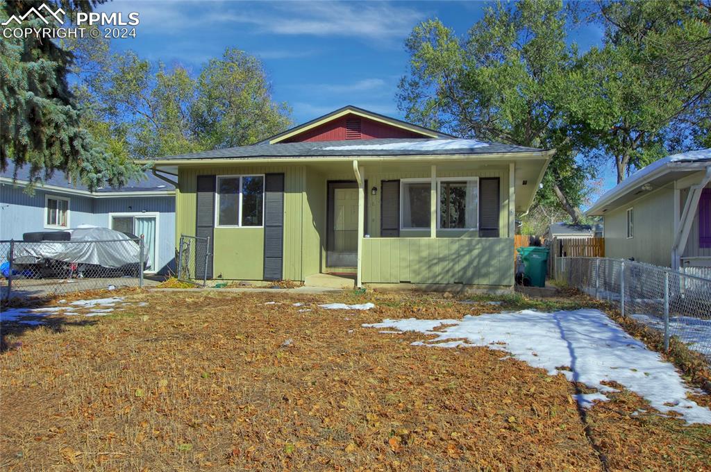 a front view of a house with a yard and potted plants