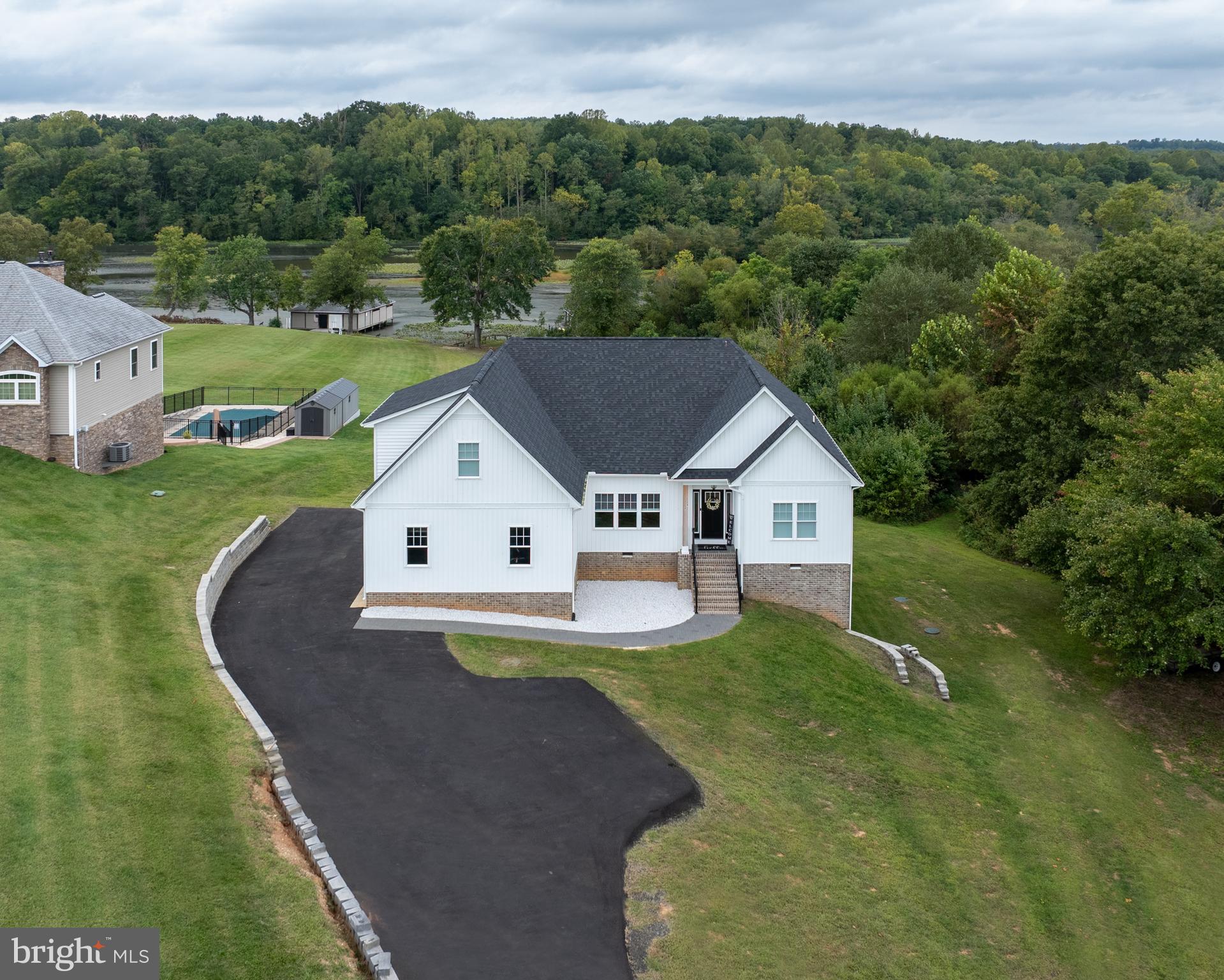 a aerial view of a house next to a big yard and large trees