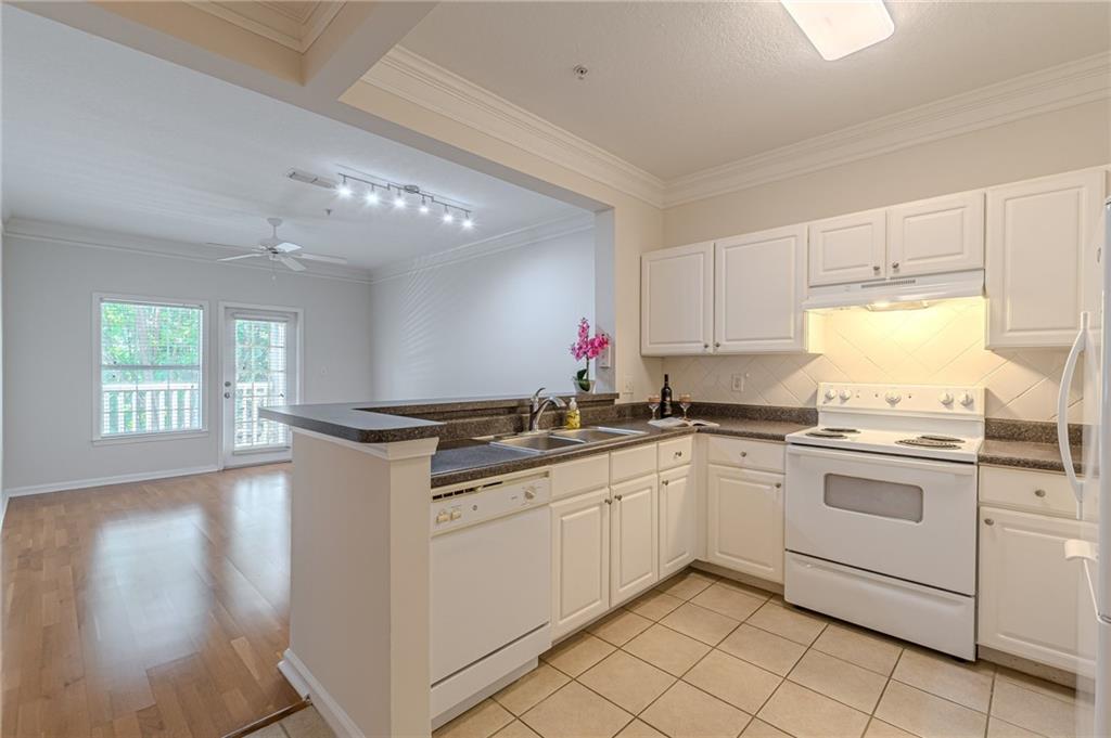 a kitchen with granite countertop cabinets sink and white appliances