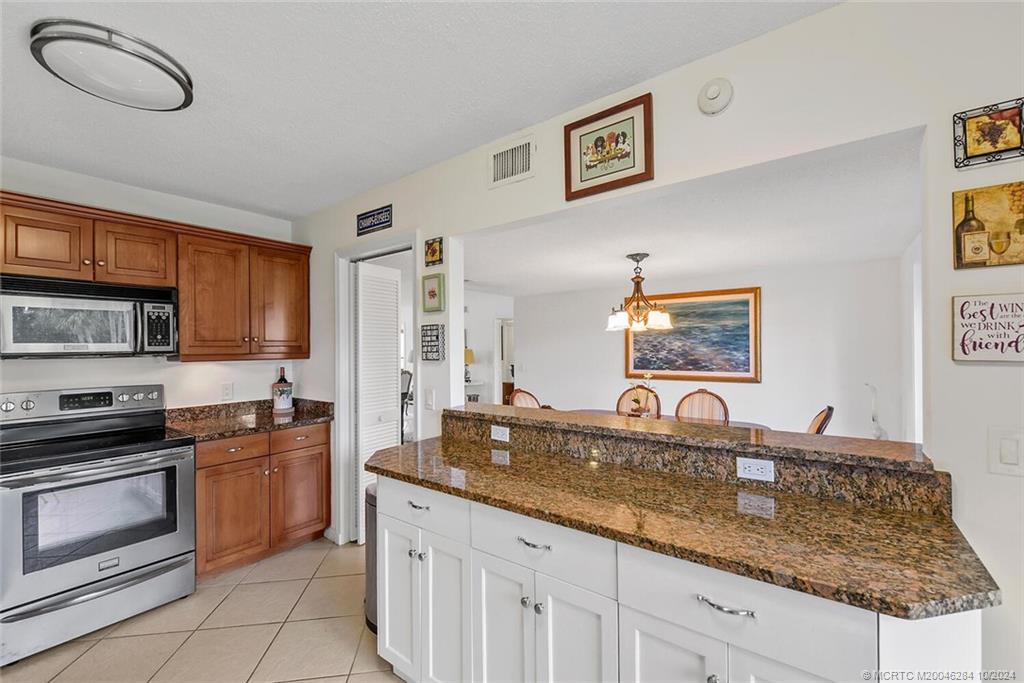 a kitchen with granite countertop a sink a stove and cabinets