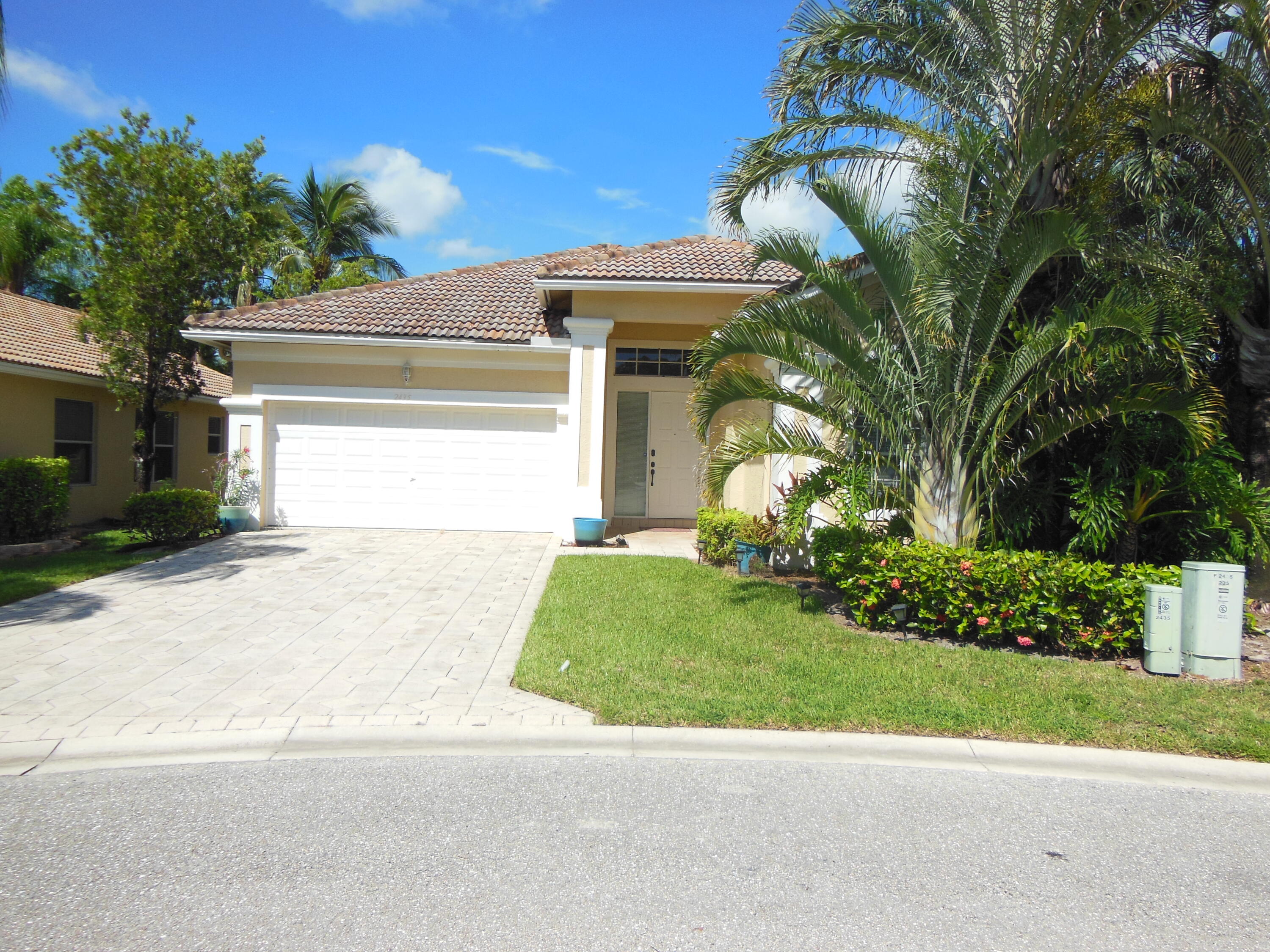 a front view of a house with a yard and a garage