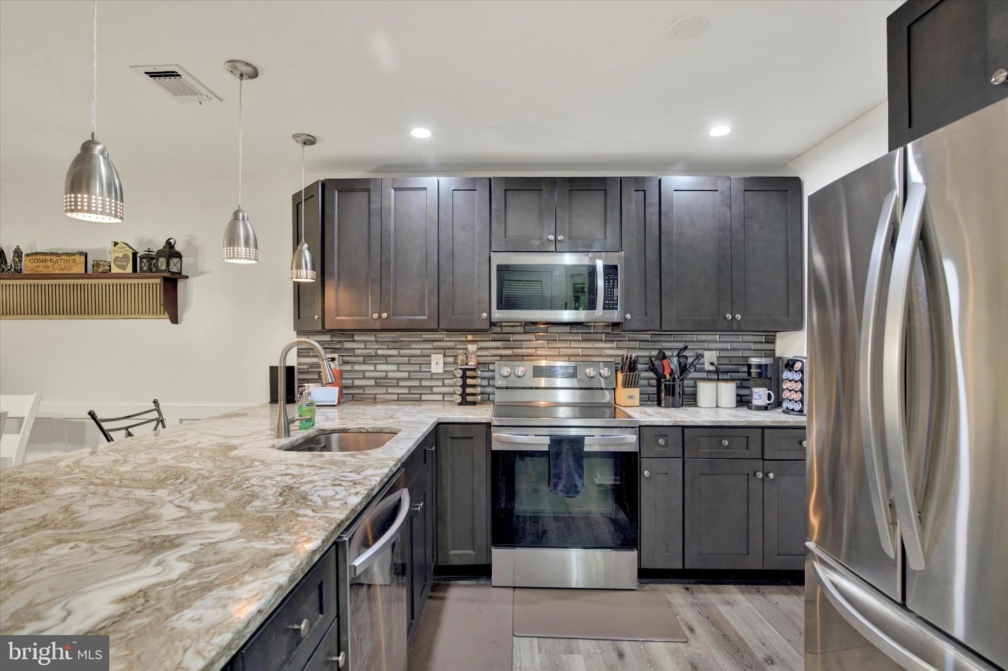 a kitchen with stainless steel appliances granite countertop a sink stove and refrigerator