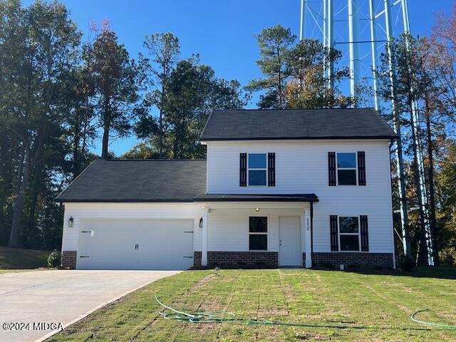 a front view of house with yard and trees in the background