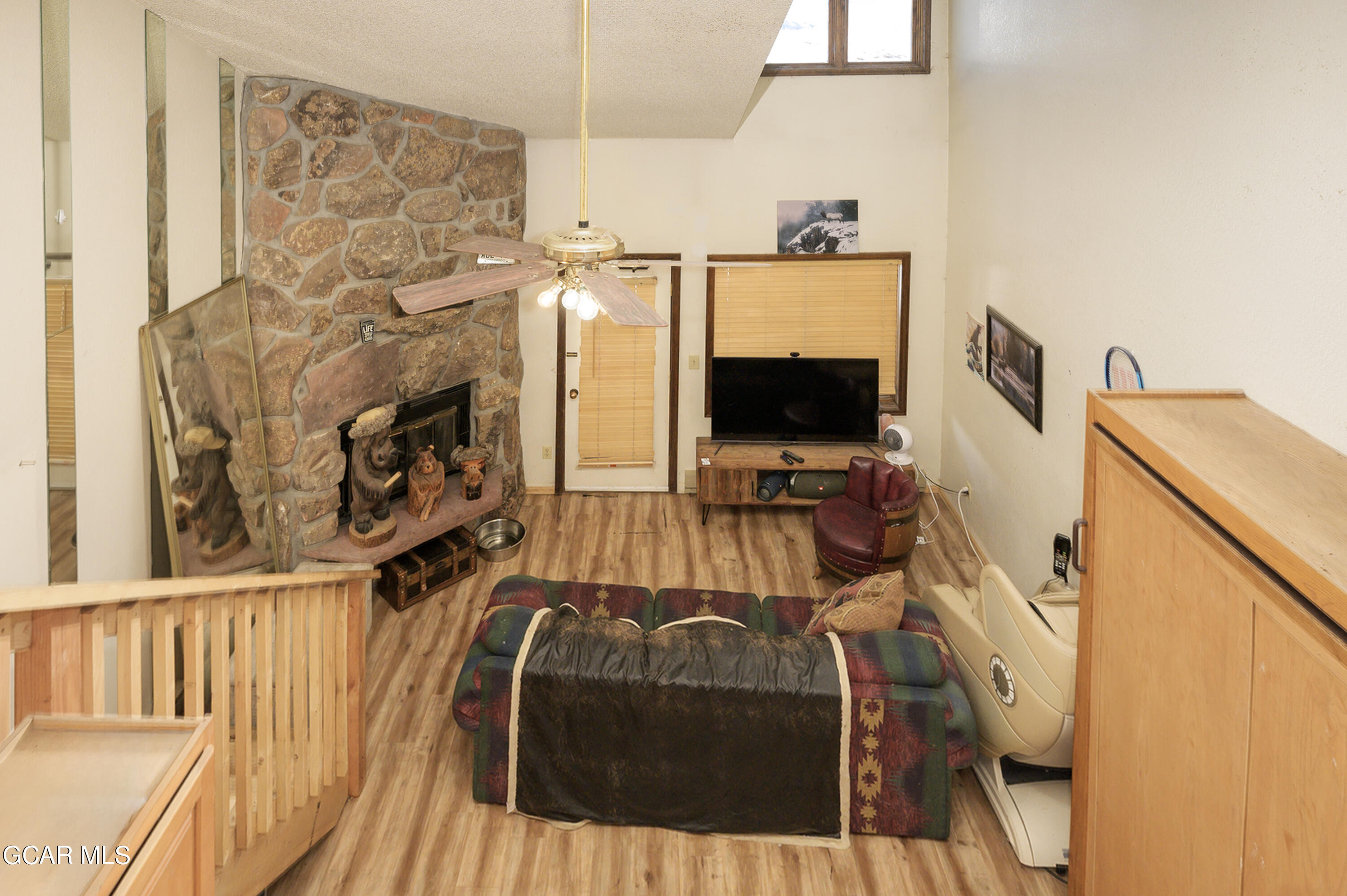 a view of a living room with a fireplace and wooden floor