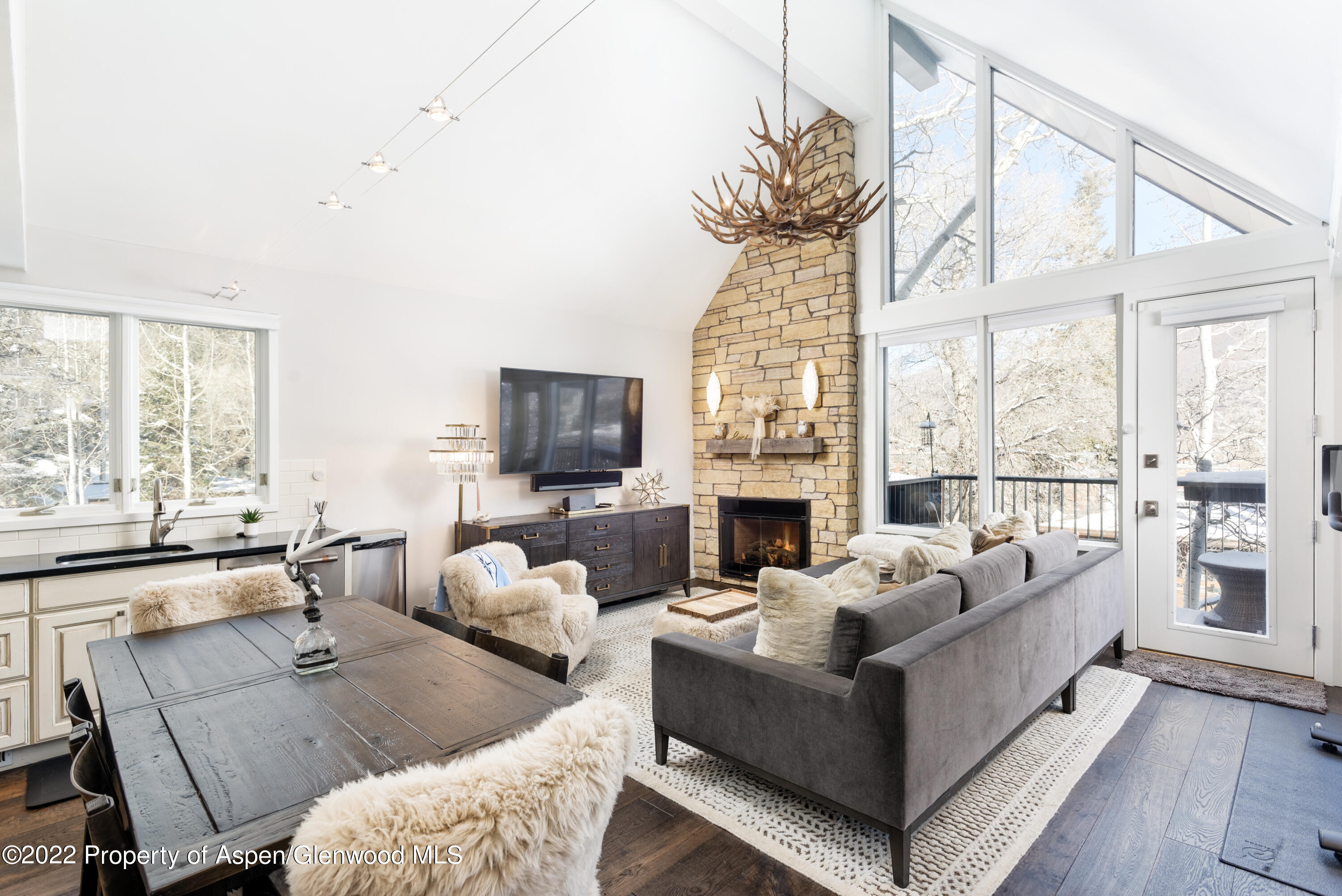 a living room with furniture a flat screen tv and a large window