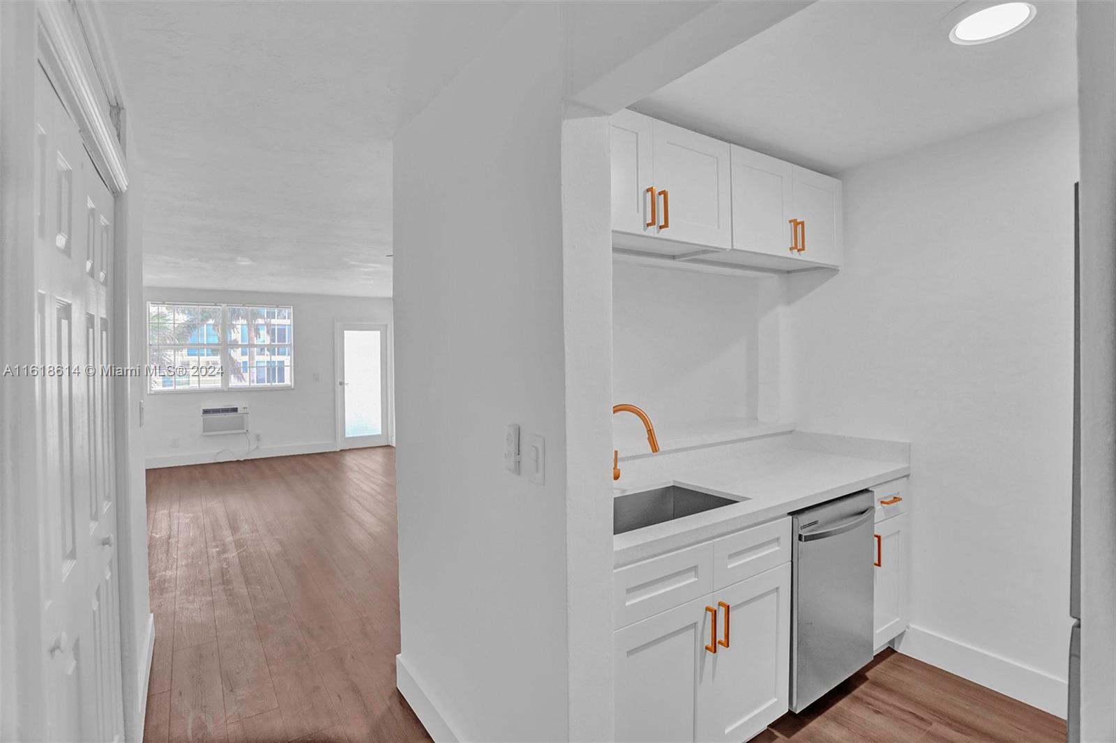 a kitchen with white cabinets and sink