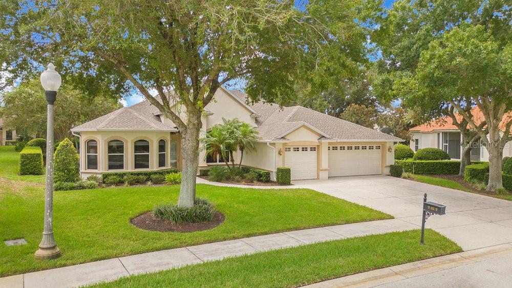 a front view of a house with a yard and trees