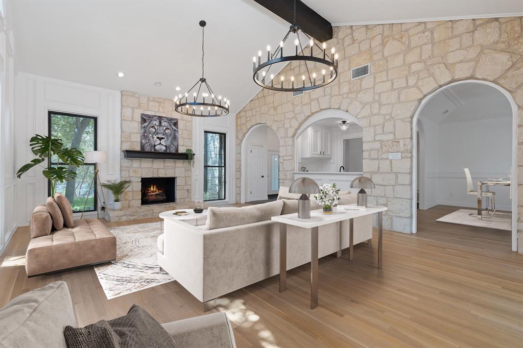 a living room with furniture a chandelier and a fireplace