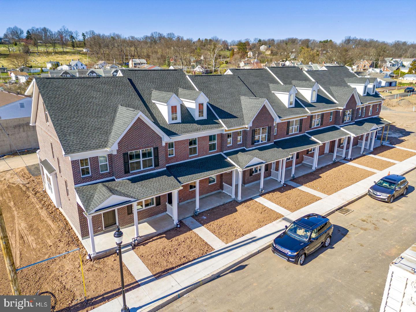 an aerial view of residential houses with outdoor space and city view