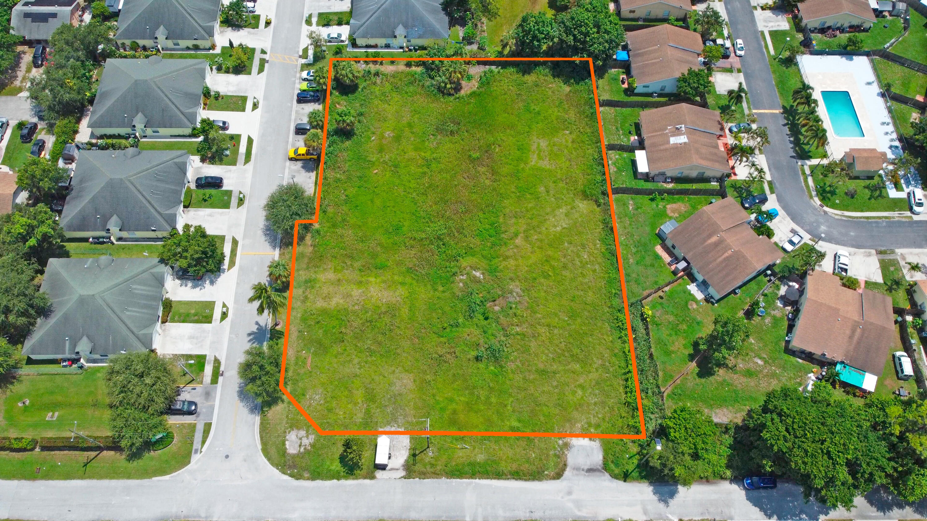 an aerial view of residential houses with outdoor space and swimming pool