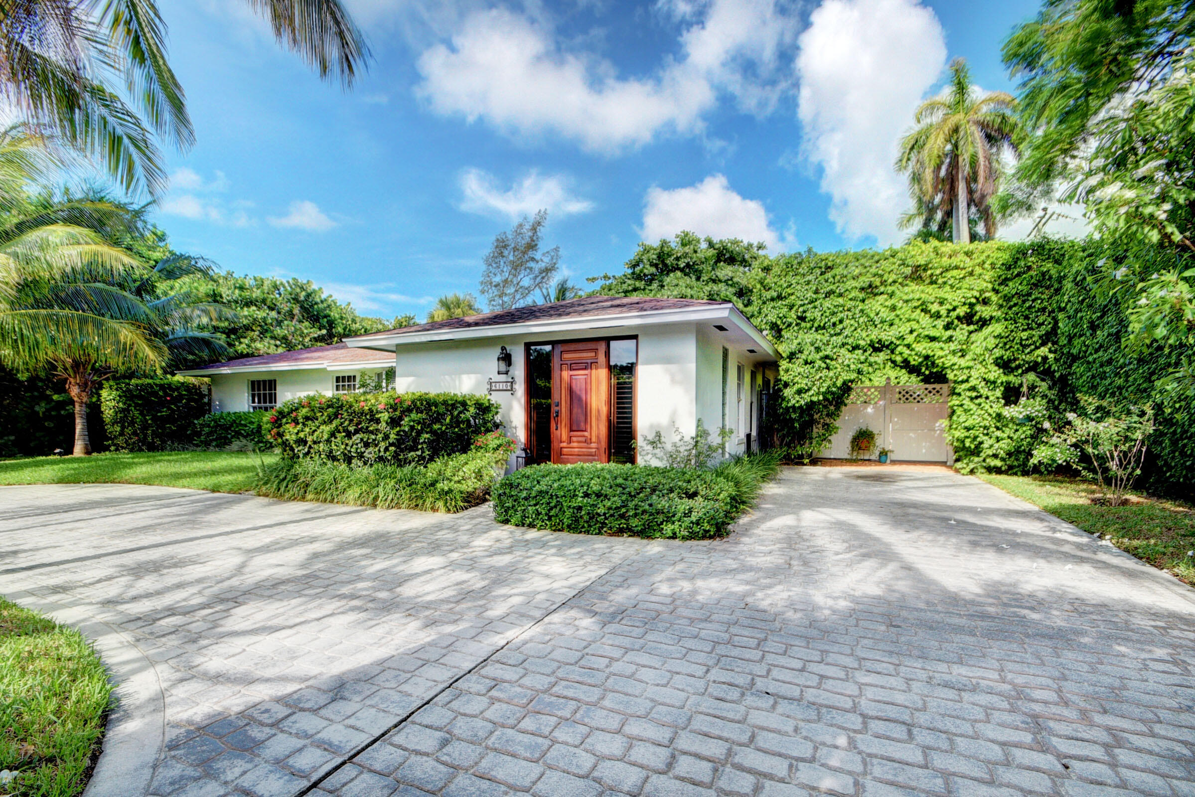 a front view of a house with a yard and potted plants