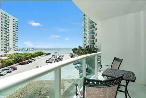 a balcony with wooden floor and outdoor seating