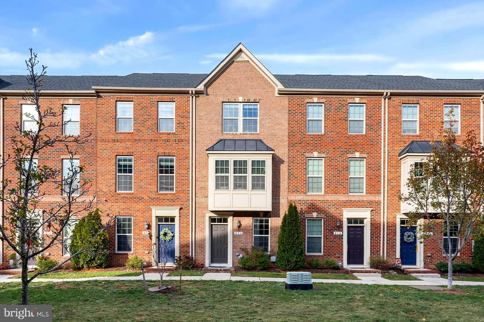 front view of a brick house with a yard