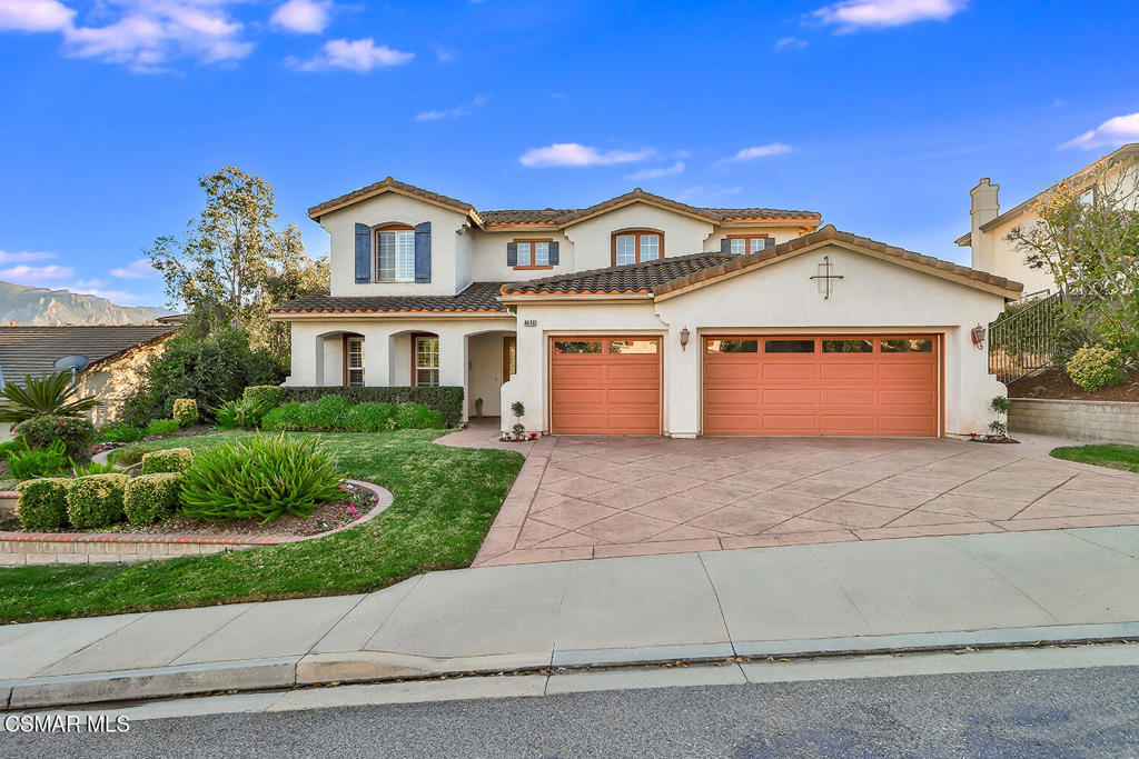 a front view of a house with a garden and garage