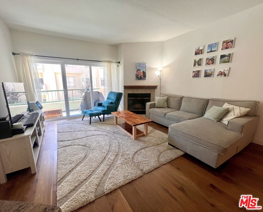 a living room with furniture fireplace and wooden floor