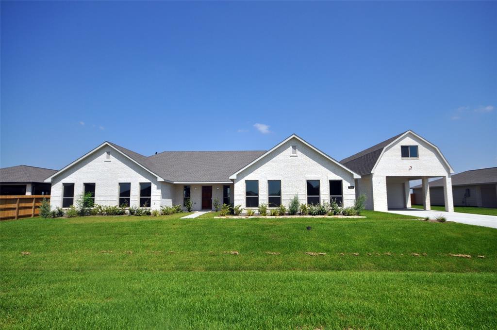 a front view of a house with a garden and trees