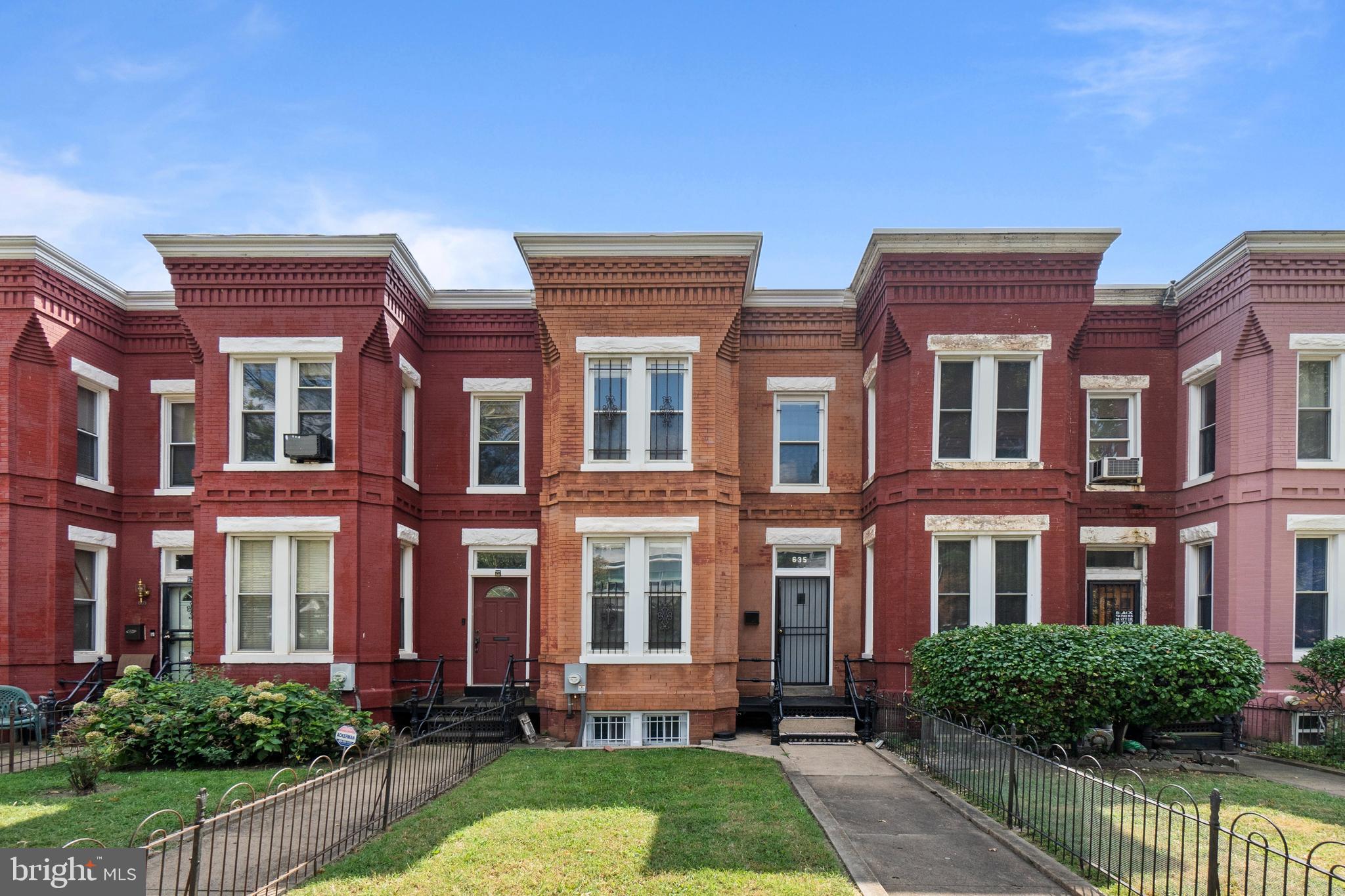 a front view of a brick house with a yard