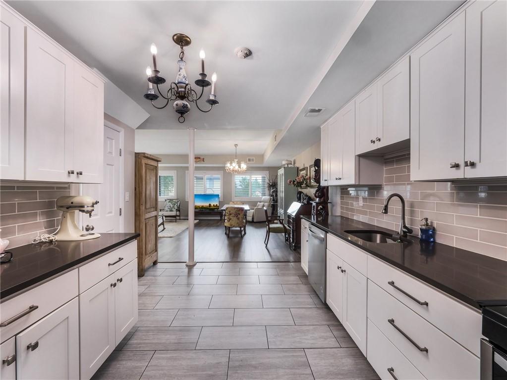 a large white kitchen with lots of counter space and stainless steel appliances