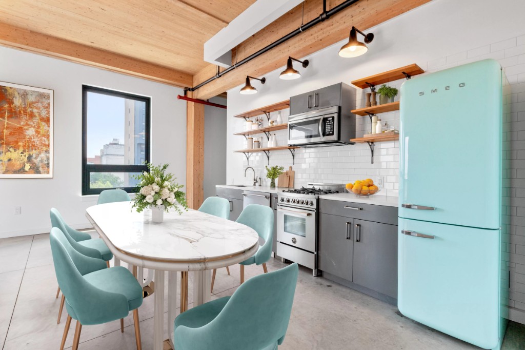 a kitchen with stainless steel appliances a dining table chairs and a refrigerator