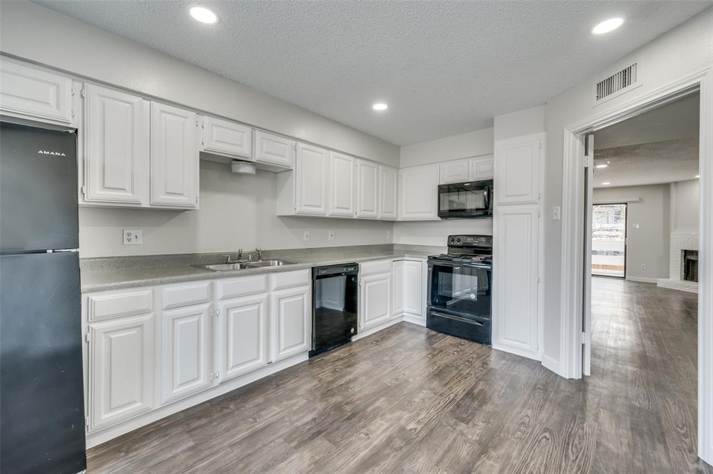 a kitchen with granite countertop white cabinets and stainless steel appliances