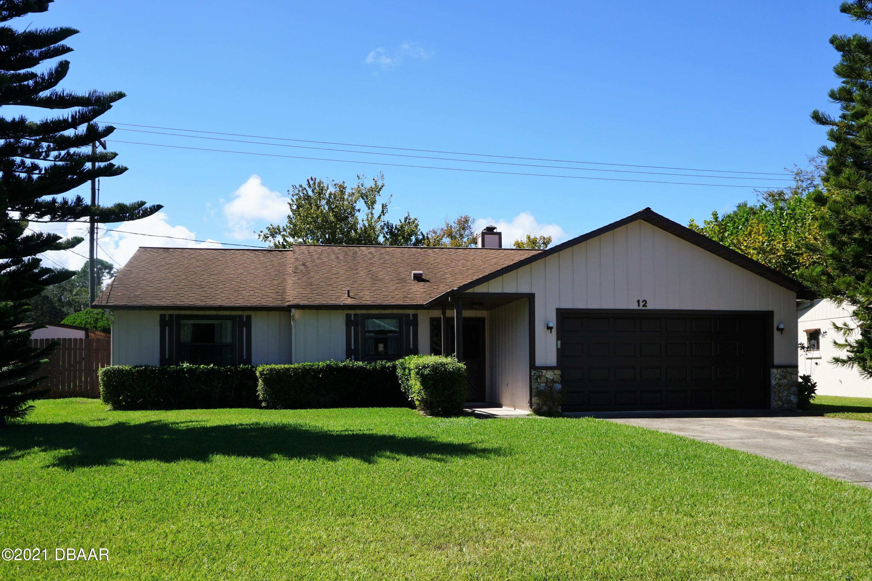 a front view of house with a garden