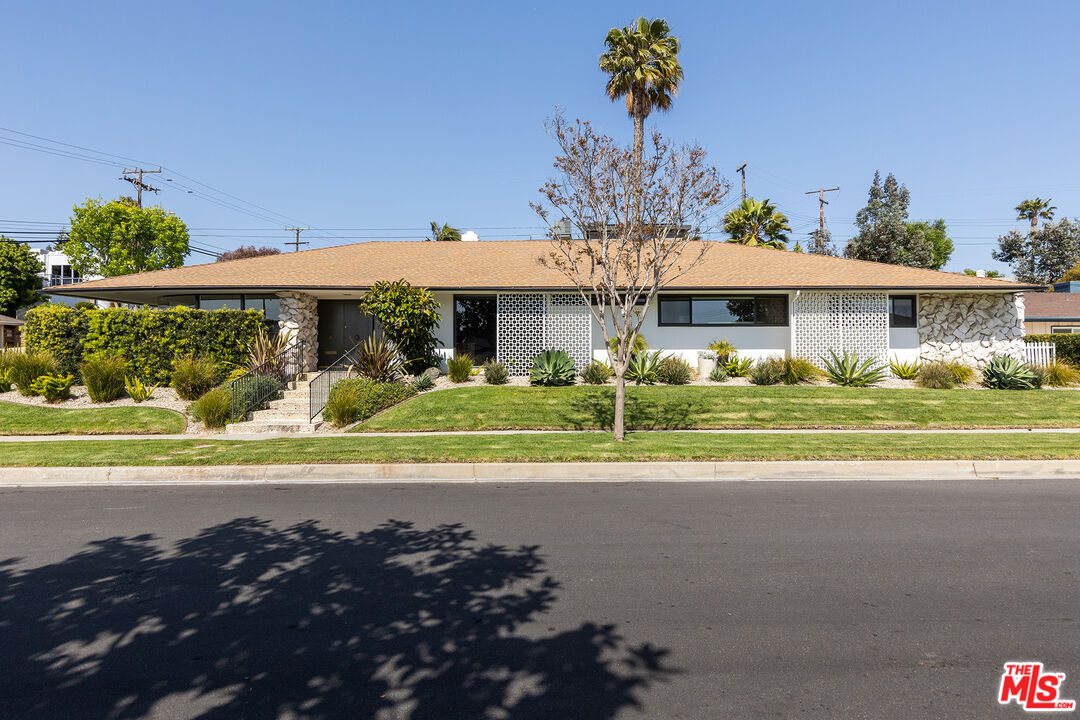 a view of a house with a big yard and potted plants