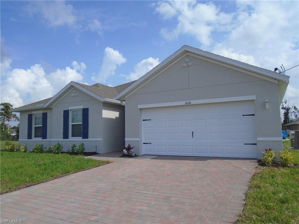 a view of a house with a yard and garage