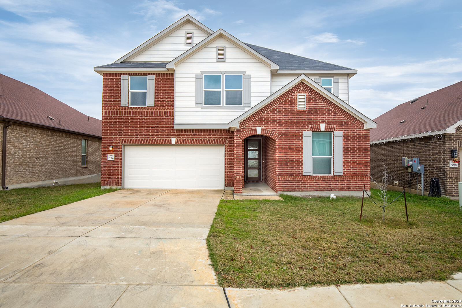 a front view of a house with a yard and garage