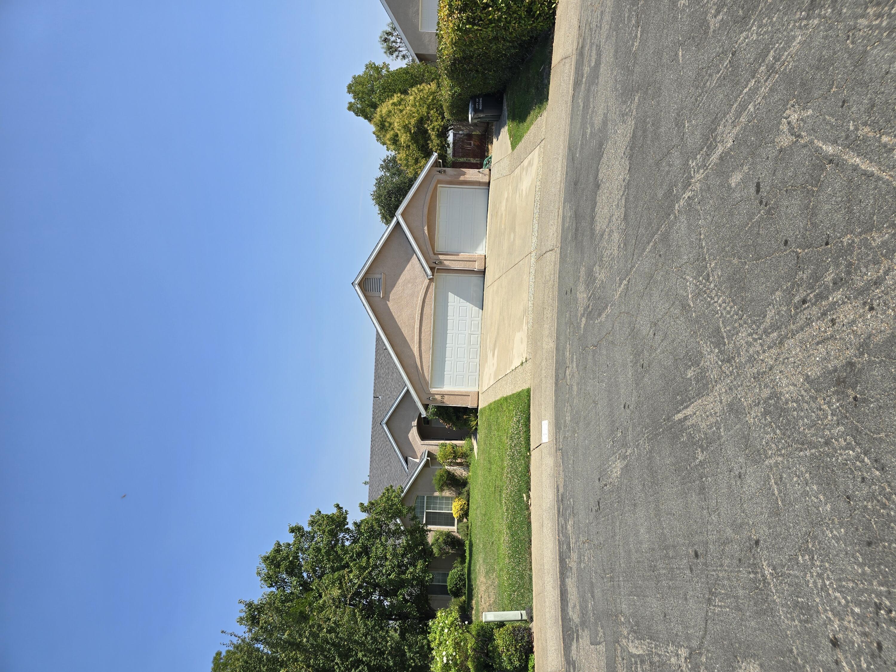 a house with a yard and a trees in the background