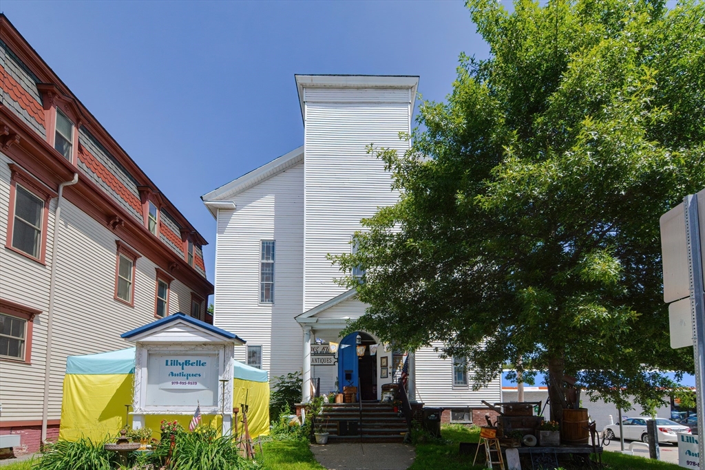 a front view of a building with trees