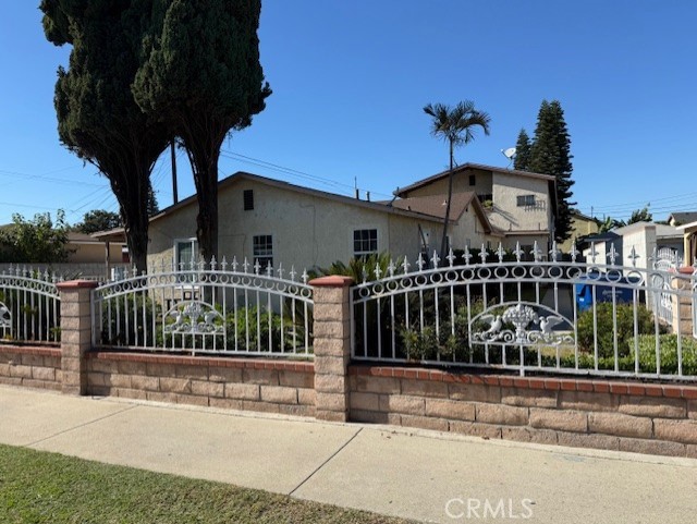 a view of a house with a small yard plants and large trees