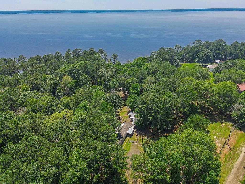 an aerial view of a houses with a yard and lake view