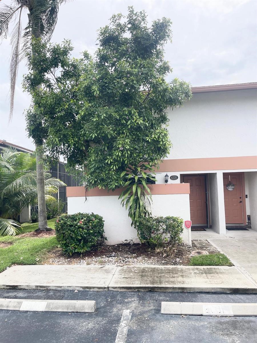 a front view of a house with a yard and potted plants