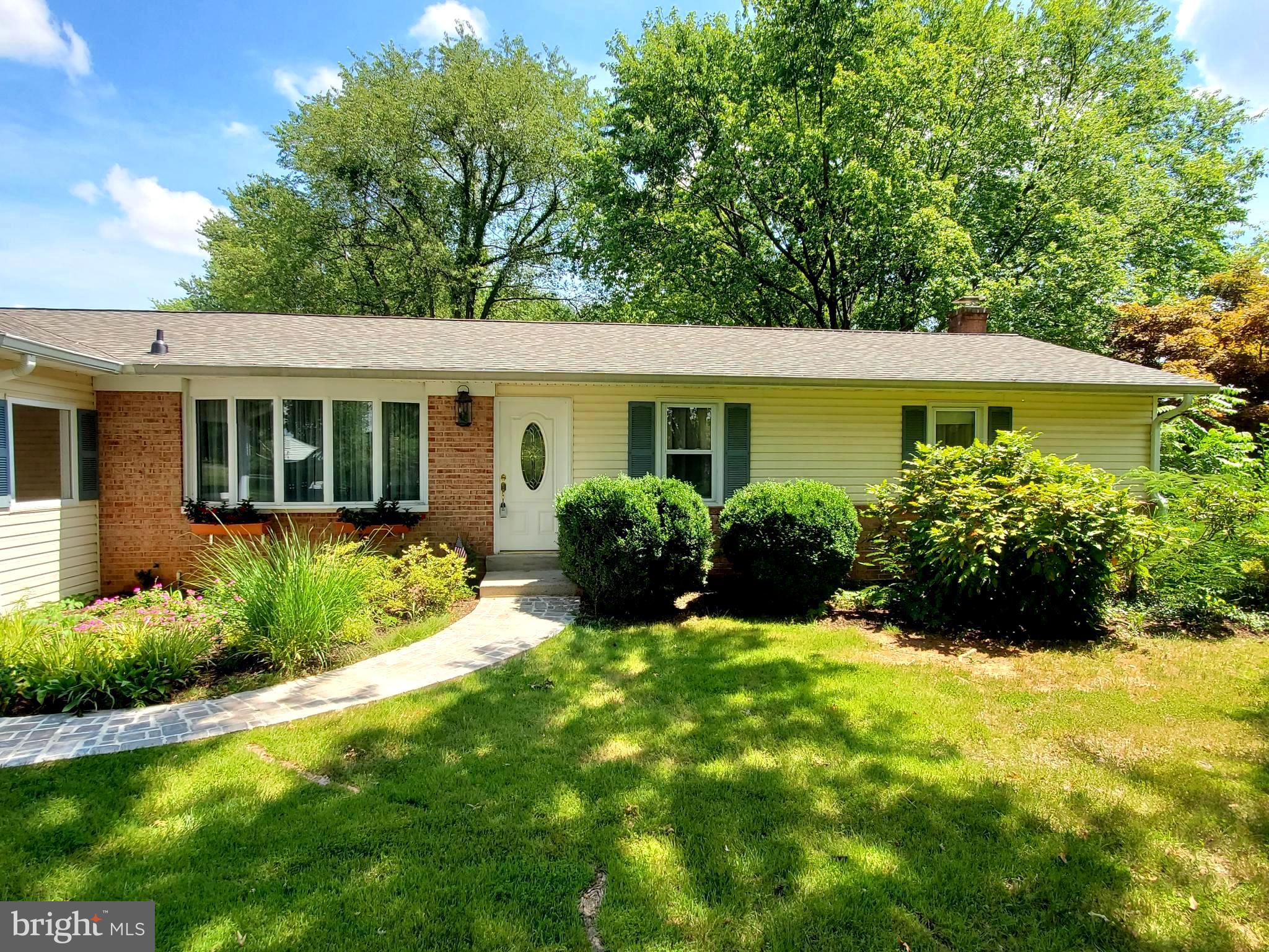 a view of a house with a yard and potted plants