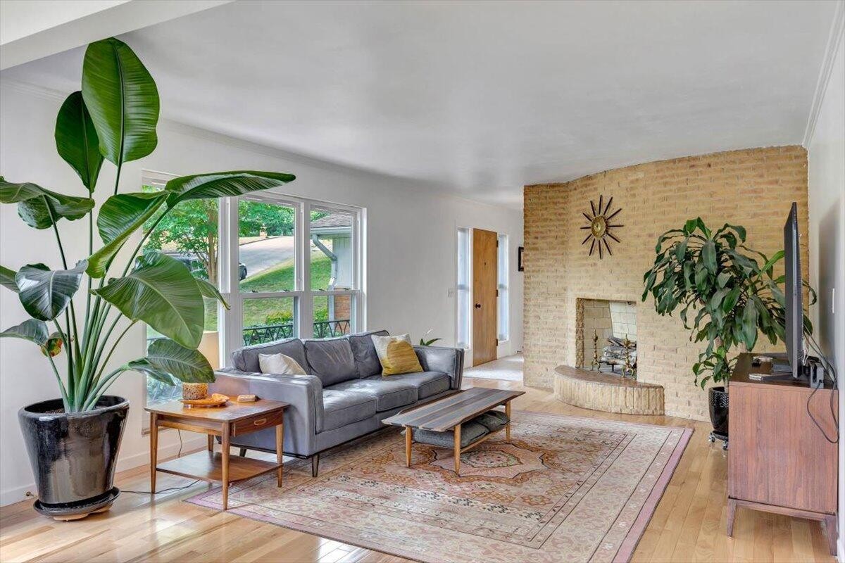 a living room with furniture potted plant and a large window