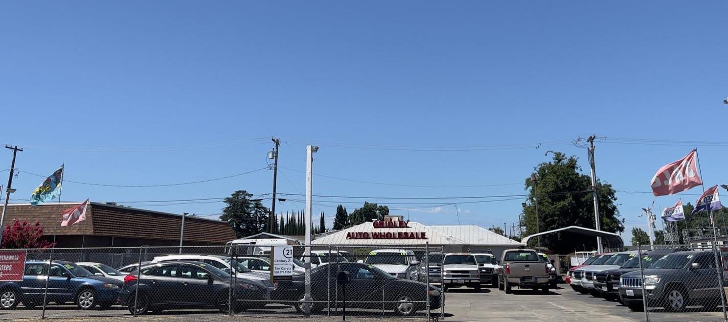 a front view of a building with cars parked