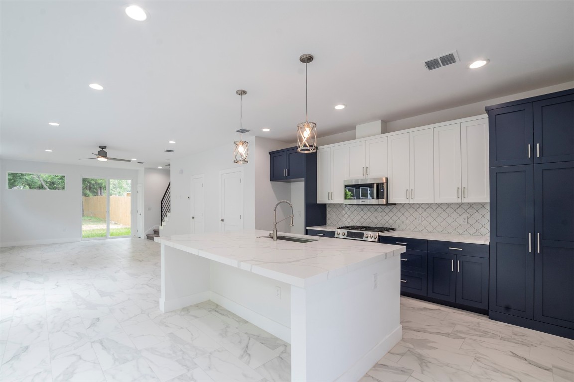 a kitchen with kitchen island a sink stainless steel appliances and cabinets