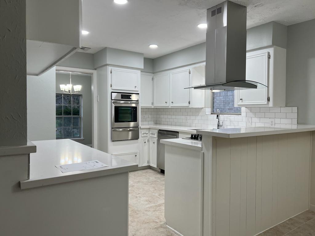 a kitchen with stainless steel appliances granite countertop a sink a stove and a refrigerator