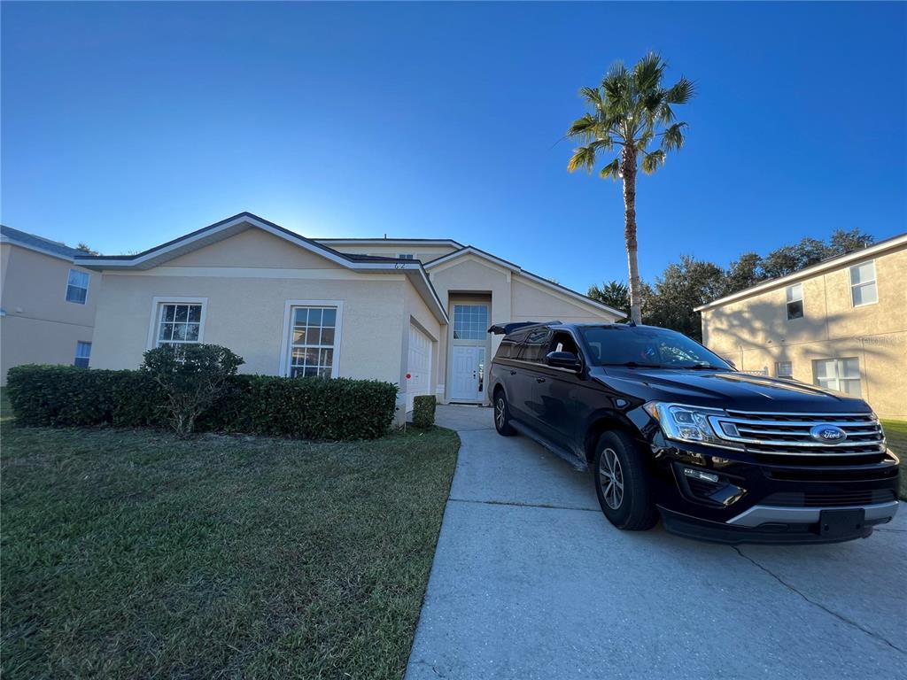 a car parked in front of a house with a yard