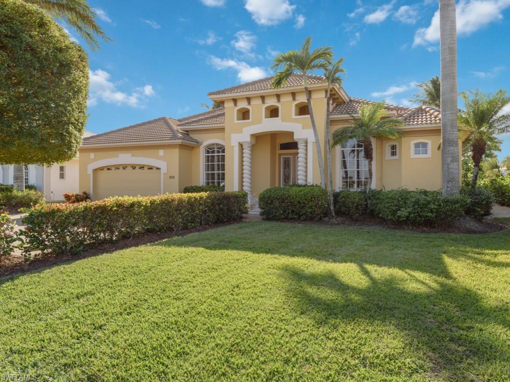 Mediterranean / spanish home featuring a garage and a front yard