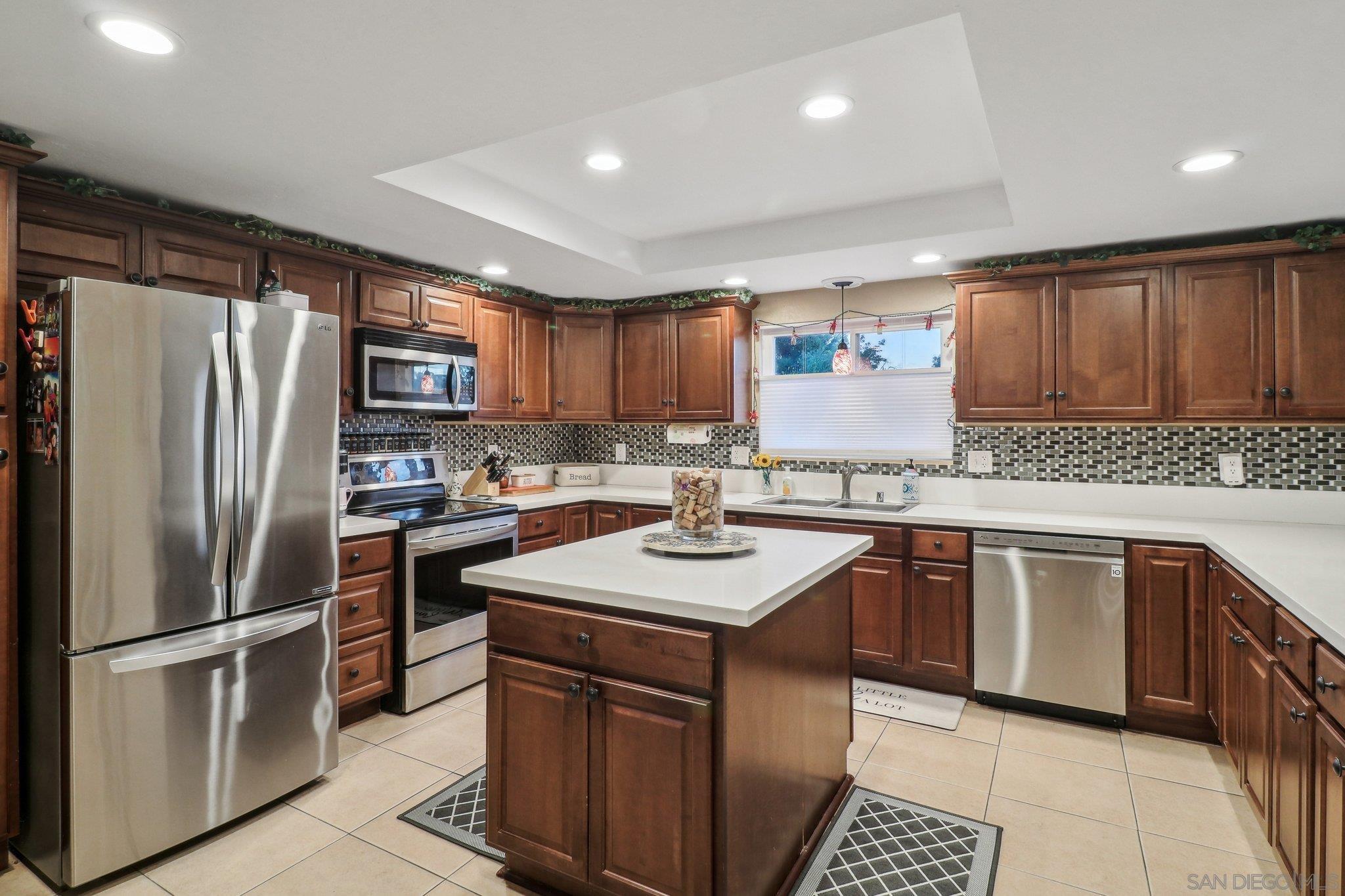 a kitchen with stainless steel appliances granite countertop a refrigerator sink stove microwave and cabinets